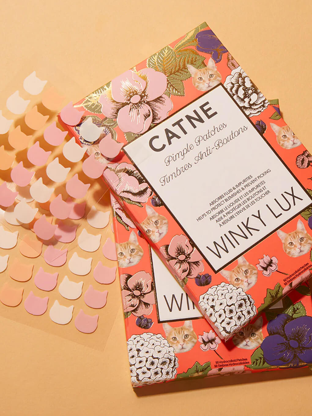 sheet of catne pimple patches next to box on pale yellow background